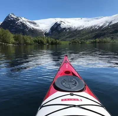 a kayak in the water with mountains in the background at Kjøsnes Feriehytter in Skei