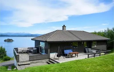 a house with a deck and a view of the water at 3 Bedroom Stunning Home In Bjoa in Utbjoa