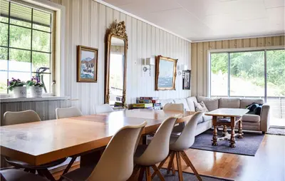 a dining room with a table and a couch at 3 Bedroom Stunning Home In Bjoa in Utbjoa