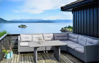 a couch on a deck with a view of a lake at 3 Bedroom Stunning Home In Bjoa in Utbjoa