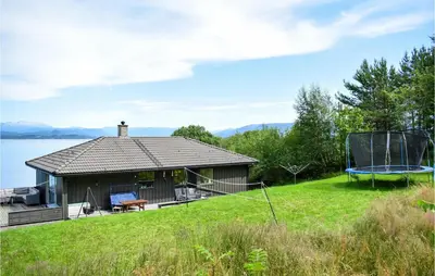 a house on the shore of a lake with a trampoline at 3 Bedroom Stunning Home In Bjoa in Utbjoa