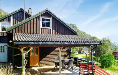 a cabin with a table and chairs in front of it at Gorgeous Home In Matre With Wifi in Hamre