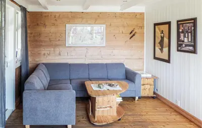 a living room with a blue couch and a table at Gorgeous Home In Matre With Wifi in Hamre