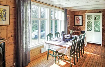 a dining room with a table and chairs and a window at Gorgeous Home In Matre With Wifi in Hamre
