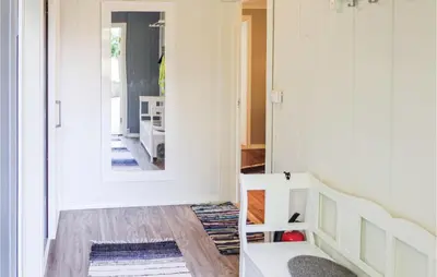 a living room with a staircase and a mirror at Gorgeous Home In Matre With Wifi in Hamre
