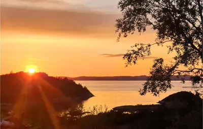 a sunset over a body of water with the sun setting at 2 Bedroom Gorgeous Home In Sveio in Sveio