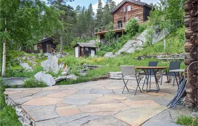 a patio with a table and chairs in front of a house at Three-Bedroom Holiday Home In Heidal in Heidal