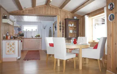 a kitchen and dining room with a table and chairs at Three-Bedroom Holiday Home In Heidal in Heidal