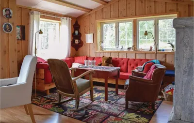 a living room with a red couch and a table at Three-Bedroom Holiday Home In Heidal in Heidal