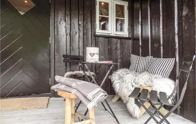 a patio with chairs and a table and a dog at Pet Friendly Home In Hovden With Sauna in Hovden