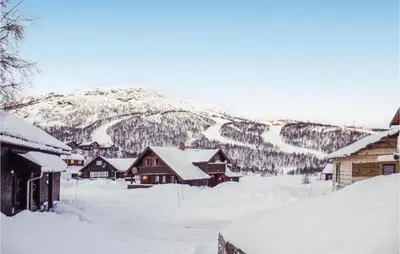 a village covered in snow with a mountain in the background at Pet Friendly Home In Hovden With Sauna in Hovden