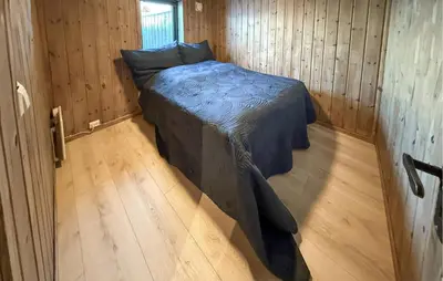 a bedroom with a bed in a wooden room at Nice Home In Hovden With Sauna in Hovden