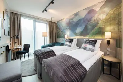 a hotel room with two beds and a desk at Scandic Flesland Airport in Bergen