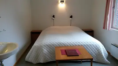 a bedroom with a bed and a sink and a table at HI Borlaug Vandrerhjem in Borgund