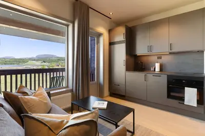 a living room with a couch and a table and a kitchen at Bjugn Hotell in Botngard