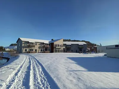 a house in the snow with tracks in the snow at Bjugn Hotell in Botngard