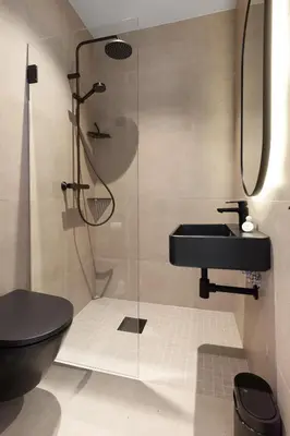 a bathroom with a shower and a black toilet and sink at Bjugn Hotell in Botngard