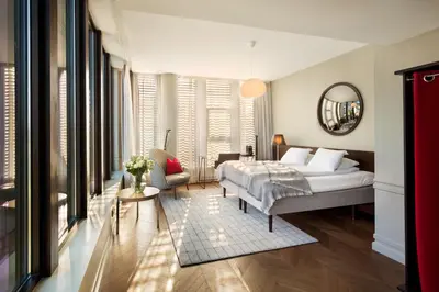 a bedroom with a bed and a living room at Bergen Børs Hotel in Bergen
