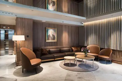 a lobby with a couch and chairs and a table at Bergen Børs Hotel in Bergen