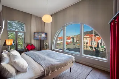 a bedroom with a large bed and a large window at Bergen Børs Hotel in Bergen
