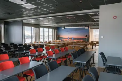 a classroom with tables and chairs and a large screen at Thon Hotel Vinstra in Vinstra