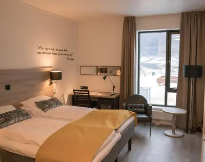 a hotel room with a bed and a desk and a window at Thon Hotel Vinstra in Vinstra