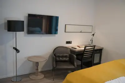 a bedroom with a desk and a chair and a television at Thon Hotel Vinstra in Vinstra