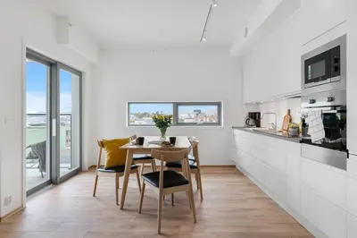 a kitchen with a table and chairs in a room at BJØRVIKA APARTMENTS, Damsgård Area, Bergen city center in Bergen