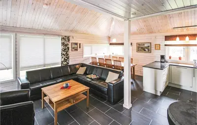 a living room with a black leather couch and a table at 3 Bedroom Stunning Home In Sjusjøen in Sjusjøen