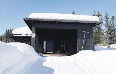 a building with a pile of snow in front of it at 3 Bedroom Stunning Home In Sjusjøen in Sjusjøen