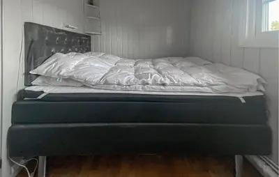 an unmade bed in a corner of a room at Cozy Home In Sjusjøen in Sjusjøen