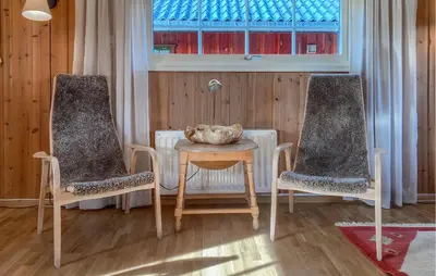 a room with two chairs and a table with a bowl on it at Cozy Home In Sjusjøen in Sjusjøen