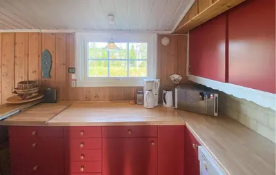 a kitchen with red cabinets and a microwave at Cozy Home In Sjusjøen in Sjusjøen