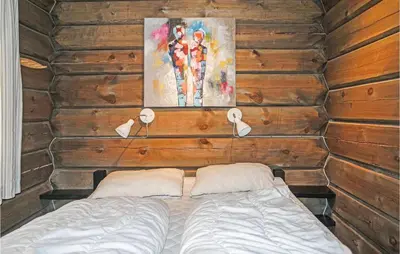a bedroom with a bed in a wooden wall at 3 Bedroom Nice Home In Sjusjøen in Sjusjøen