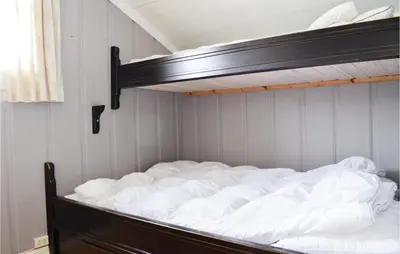 a bed with white sheets on it in a room at Sjusjøen Setergrend 4730 in Sjusjøen