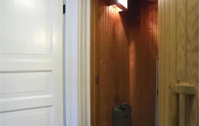 a door with a trash can next to a wooden wall at Sjusjøen Setergrend 4730 in Sjusjøen