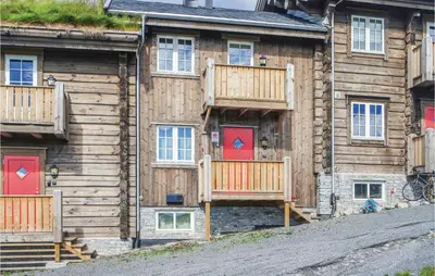 a log cabin with red doors and a deck at Sjusjøen Setergrend 4763 in Sjusjøen