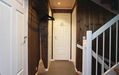 a hallway with a white door and a broom at Sjusjøen Setergrend 4763 in Sjusjøen