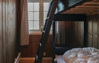 a bedroom with a bunk bed and a window at Sjusjøen Setergrend 4763 in Sjusjøen