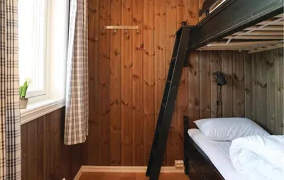 a bedroom with a bunk bed in a wooden wall at Sjusjøen Setergrend 4763 in Sjusjøen