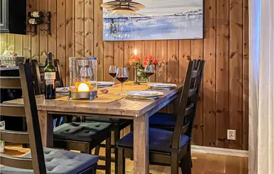 a wooden table with chairs and wine glasses at Sjusjøen Setergrend 4763 in Sjusjøen
