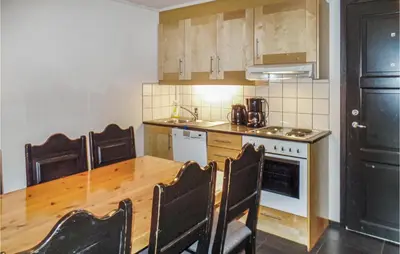 a kitchen with a wooden table with chairs and a stove at Gorgeous Apartment In Hemsedal in Hemsedal