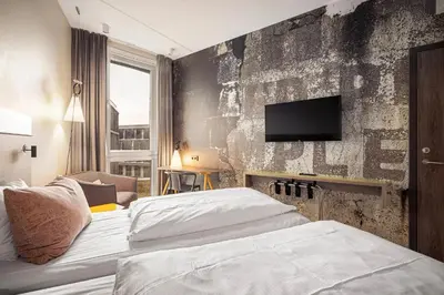 a hotel room with two beds and a flat screen tv at Comfort Hotel Bergen Airport in Bergen
