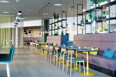 a restaurant with yellow and blue tables and chairs at Comfort Hotel Bergen Airport in Bergen