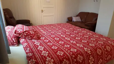 a bedroom with a red bed with a red and white blanket at Egil's Vacation House in Lillehammer