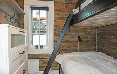 a bedroom with a bunk bed in a wooden wall at Sjusjøen Setegrend 4733 in Sjusjøen
