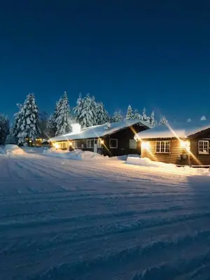 a cabin in the snow at night with lights on at Sæteråsen Hytter & Camping Trysil in Trysil