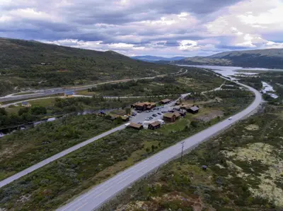 an aerial view of a road with houses next to a highway at Dovregubbens Hall in Vålåsjø