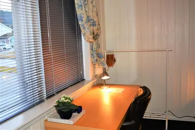 a desk with a lamp in a room with a window at Løvheim Gjestehus - Anneks in Sauland