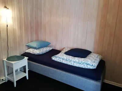 two beds in a room with a table and a lamp at Løvheim Gjestehus - Anneks in Sauland
